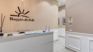 A reception desk with a sign reading "Raggio di Sole" and a map. There are two decorative vases on the counter. - RAGGIO DI SOLE - ATAROOMS Collection (Naples)