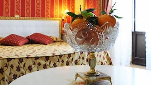 Una habitación con una cama, una mesa y un cuenco de vidrio decorativo, y una pared con un diseño llamativo.