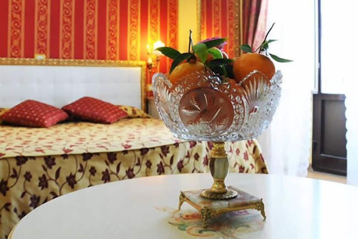 Una habitación con una cama, una mesa y un cuenco de vidrio decorativo, y una pared con un diseño llamativo.