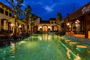 A pool area with lounge chairs and a bar area with a sign reading "Villa Sottile". - Villa Seville (Hua Hin)