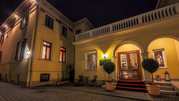 Un immeuble à la façade jaune, doté d’un balcon et d’un escalier menant à l’entrée.