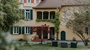 Une maison à deux étages avec une piscine en premier plan.