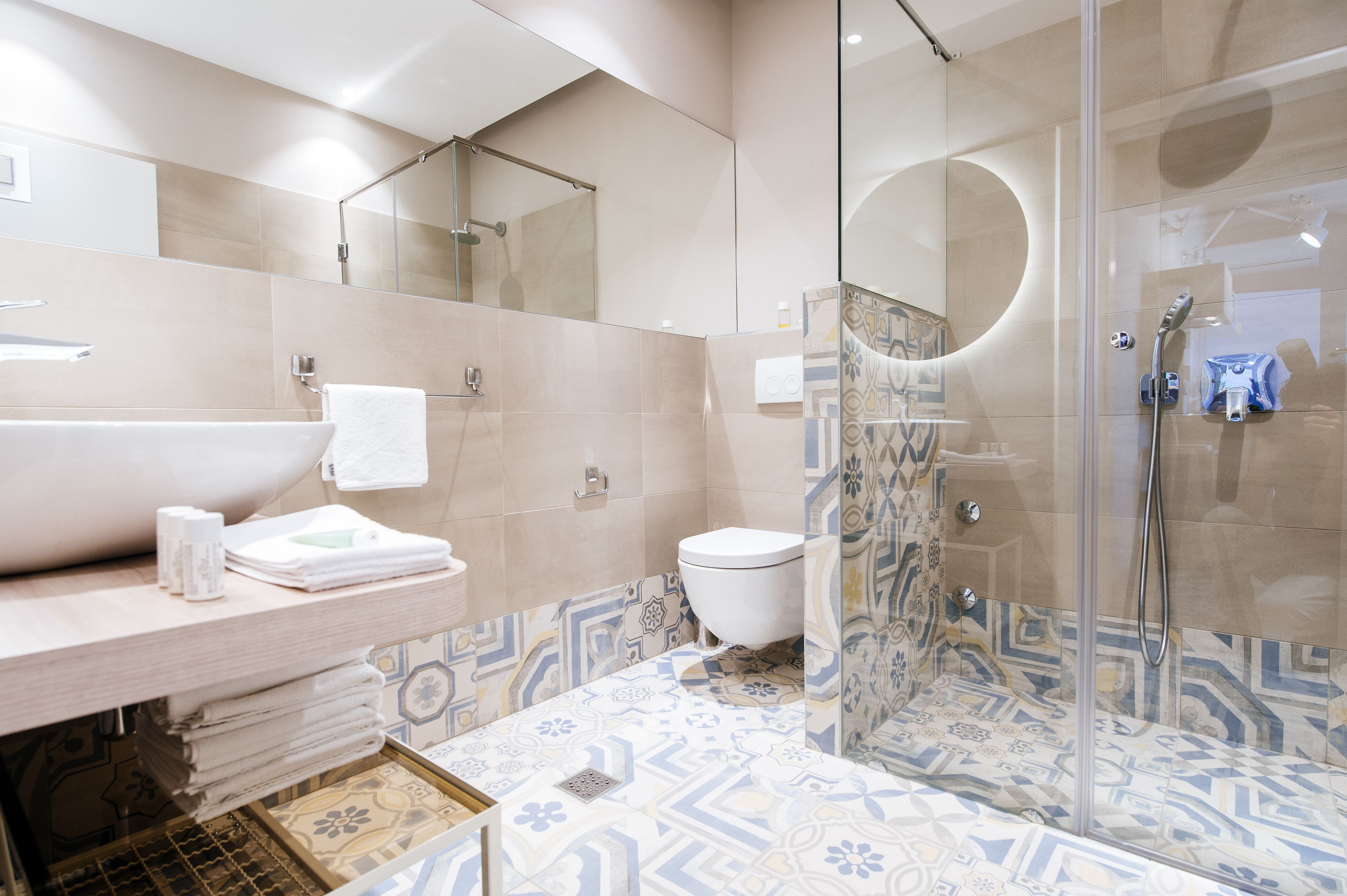 Une salle de bain moderne avec une douche à parois de verre, des toilettes blanches et un meuble-lavabo avec un miroir.