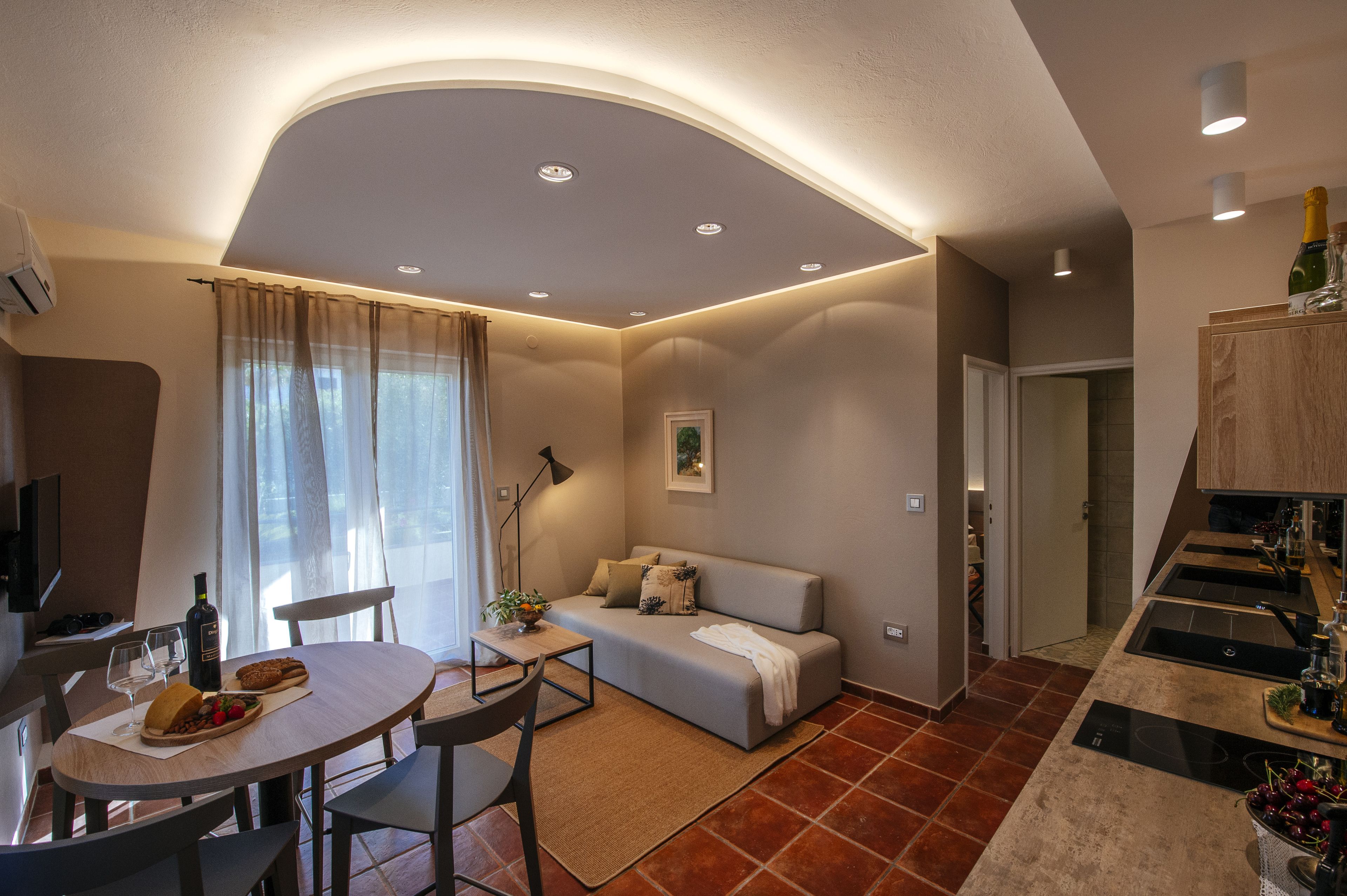 A compact living space with a dining area, a sofa, and a kitchenette.