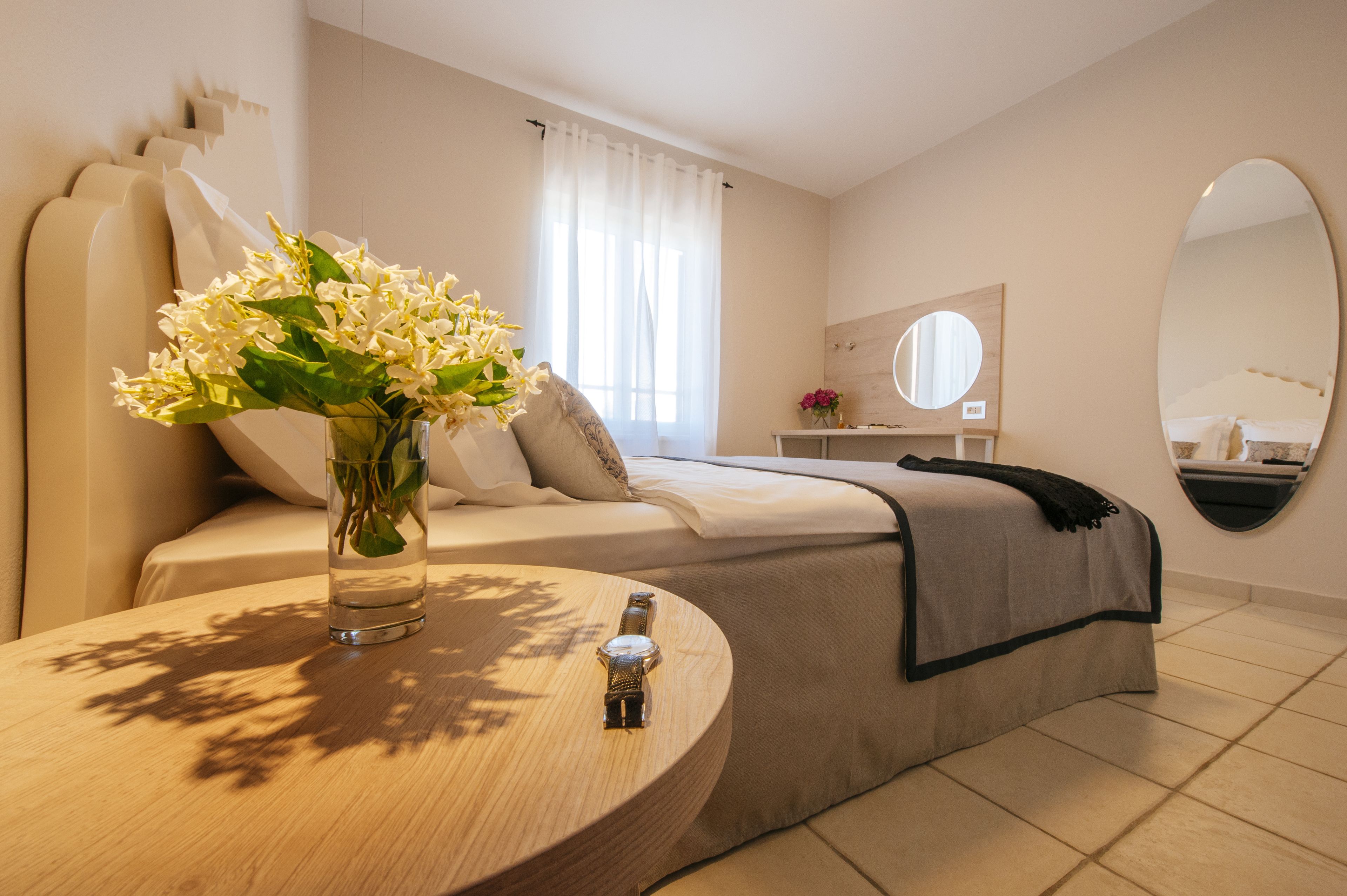 Une chambre à coucher moderne avec un lit, une table de chevet et un miroir.