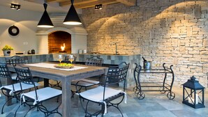 A cozy kitchen with a stone wall, a wooden dining table, and black chairs.