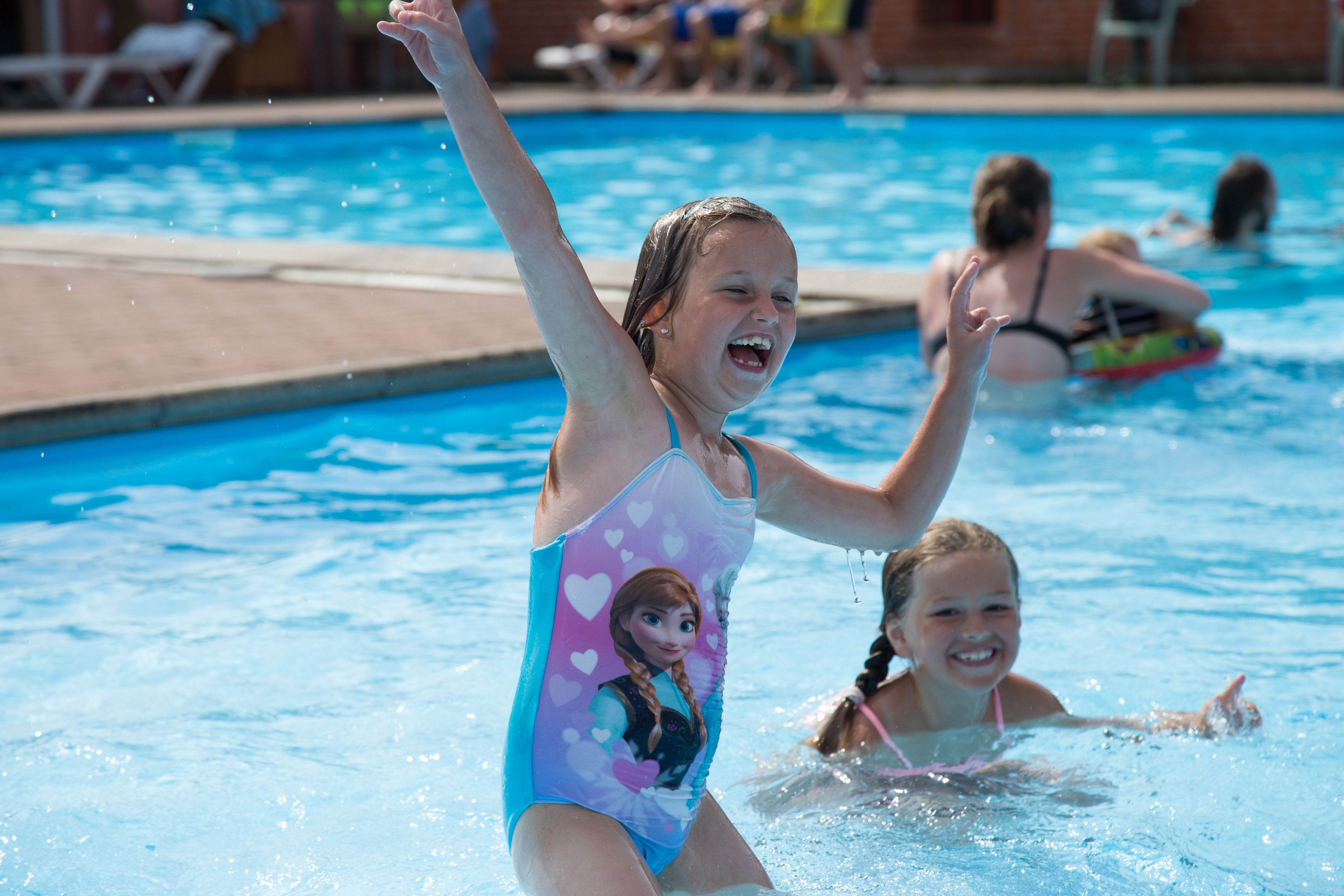A swimming pool with people in the water.