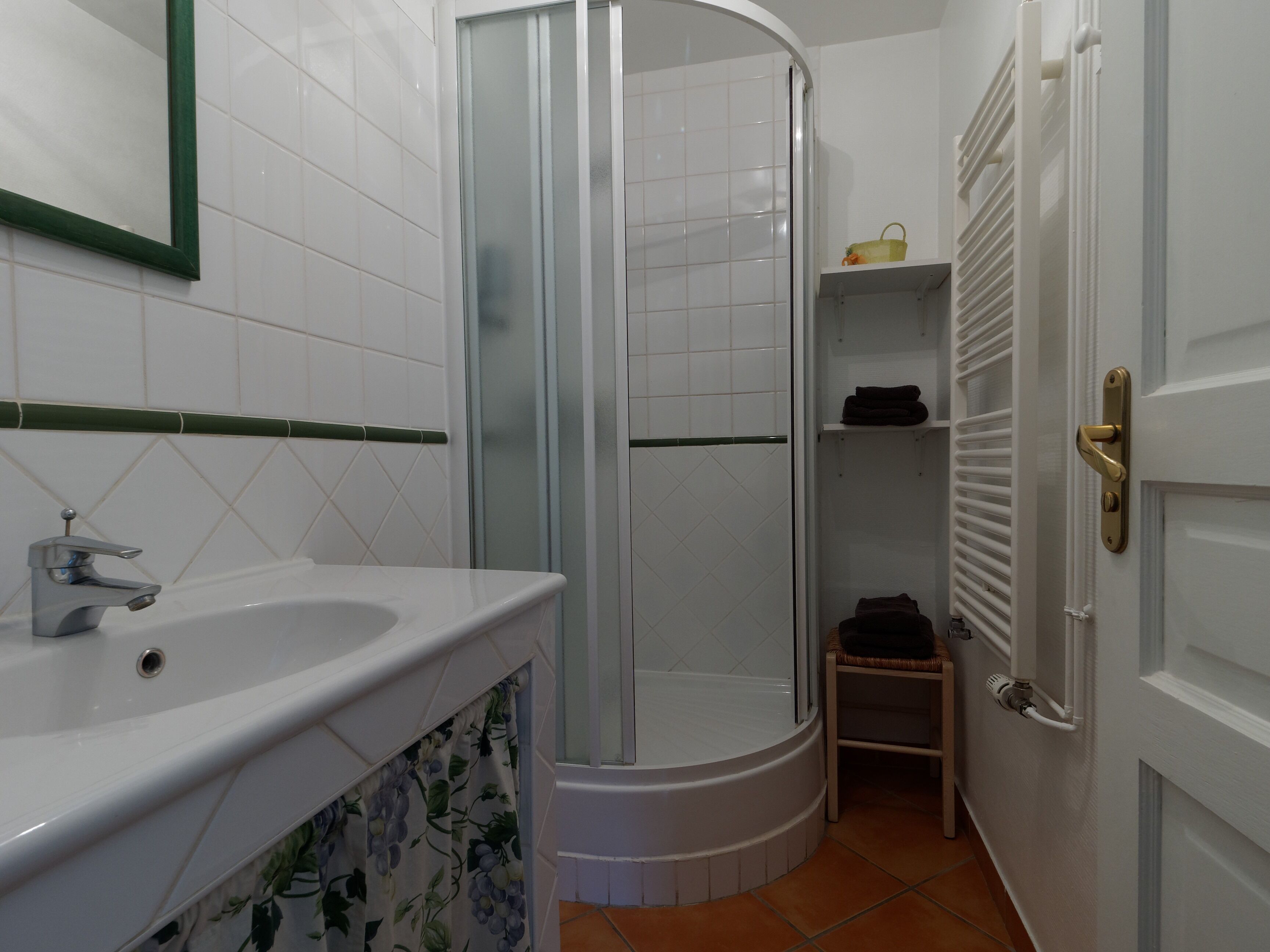 Een badkamer met een douche, een wastafel en een toilet.
