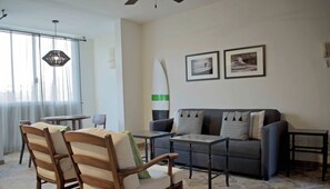 A living room with a sofa, two armchairs, a coffee table, and a surfboard decoration. - "Tortuga",  one bedroom apartment. You can walk to Beach and Restaurants (Punta de Mita)