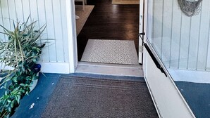 A doorway leading into a room with a bed, a television, and a ceiling fan. - Private luxury studio- 10 mins downtown and Folly (Charleston County)