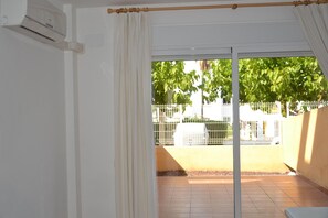 Ein Zimmer mit einer Schiebetür zu einer Außenpatio-Terrasse.