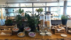 A buffet table with various food items and plants. - SLAVIERO Campina Grande (Campina Grande)