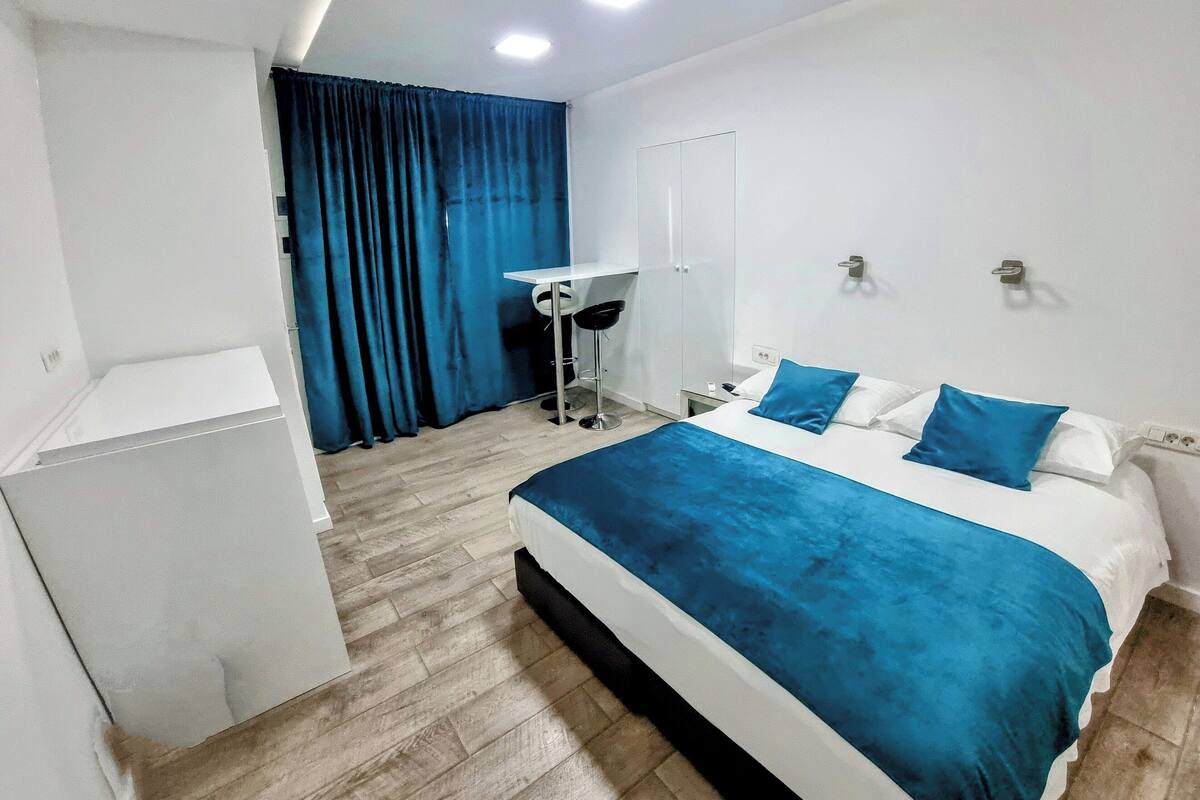 Quarto de hotel moderno com uma cama grande, uma escrivaninha e uma cadeira.