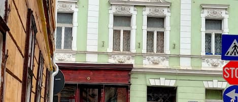 Un edificio histórico con detalles arquitectónicos ornamentales y fachada verde.