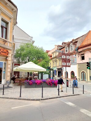A cobblestone street with outdoor seating and flower boxes.