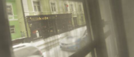 A cafe with outdoor seating visible through a window.