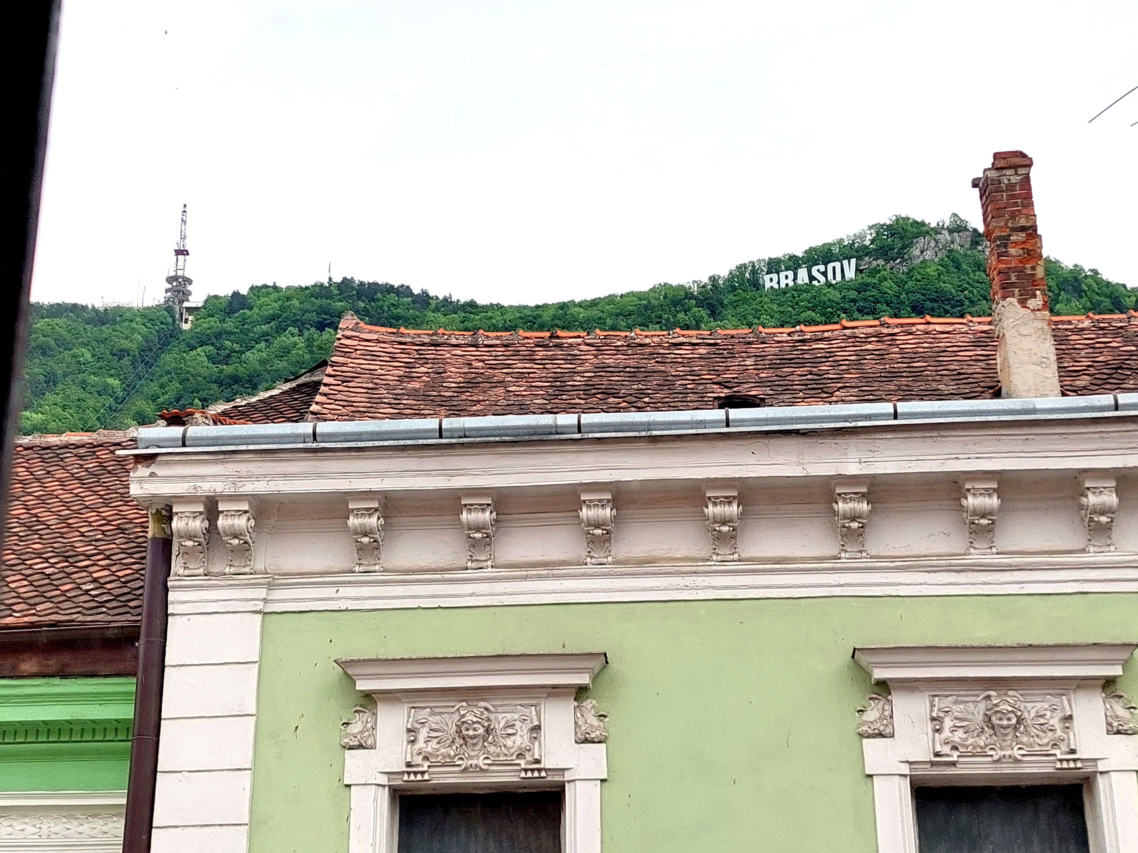 A building with a green facade and a tiled roof.