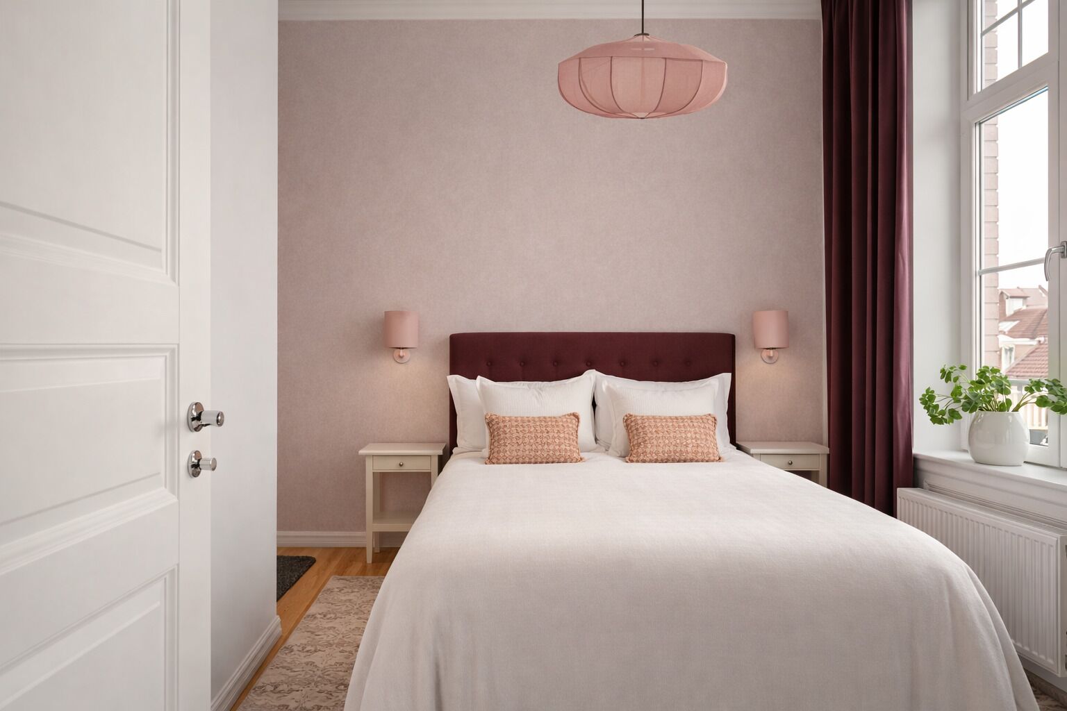A neatly arranged bedroom with a bed, bedside lamps, a hanging light fixture, and a window with curtains.