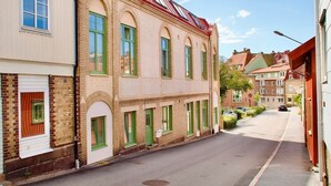 A narrow street lined with traditional European-style buildings, featuring arched windows and a mix of brick and plaster facades. - L Boutique Hotel (Lysekil)
