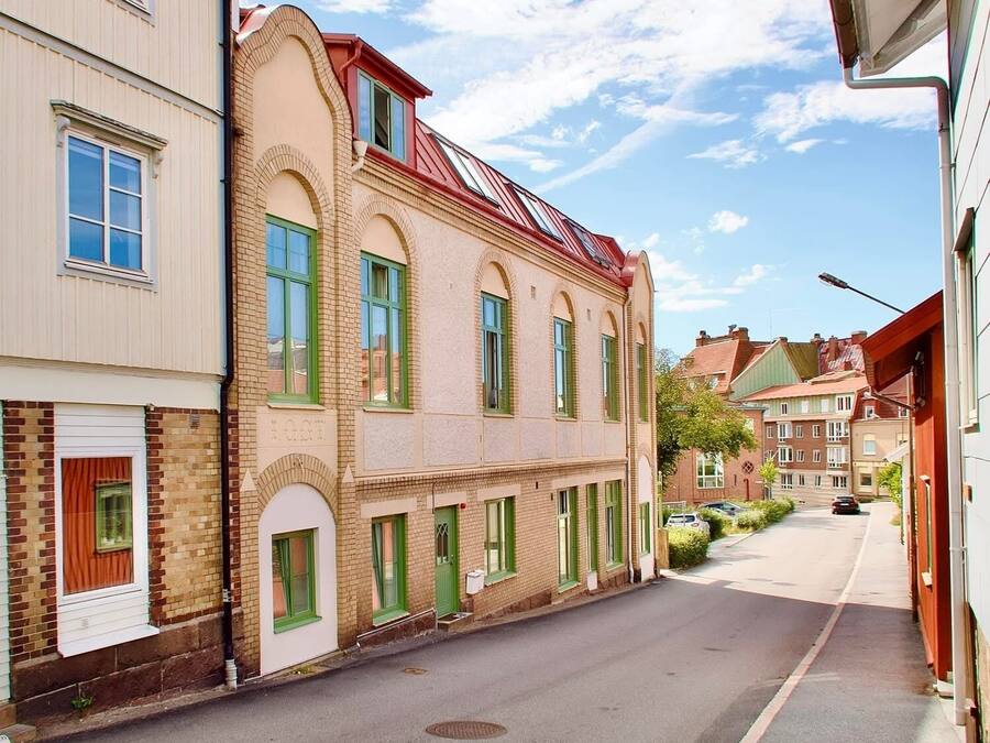 A narrow street lined with traditional European-style buildings, featuring arched windows and a mix of brick and plaster facades.