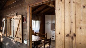Een houten cabinestijl interieur met een eethoek, een keuken en een bord met het cijfer '5' aan de muur.
