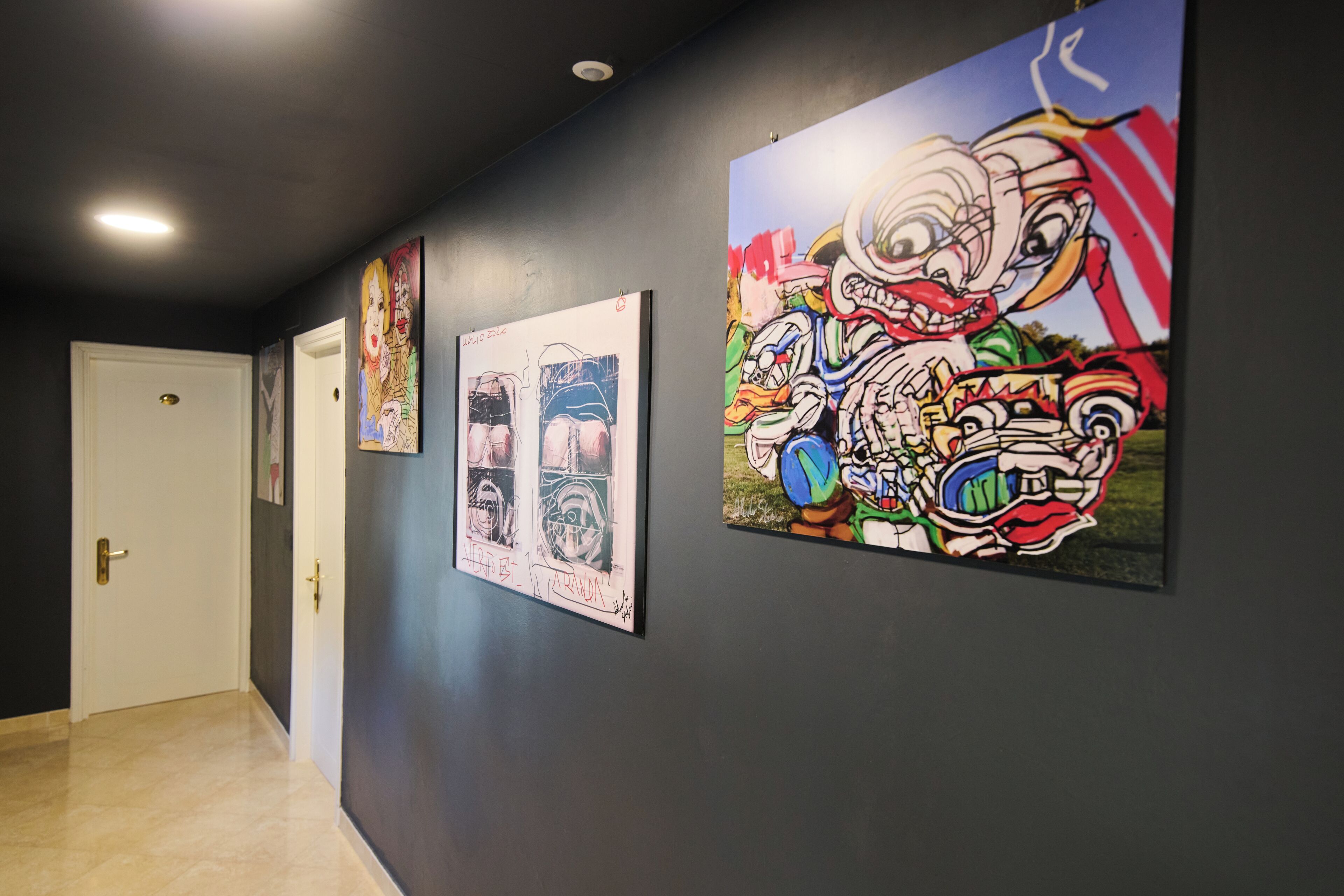 A hallway with three framed artworks on the wall.