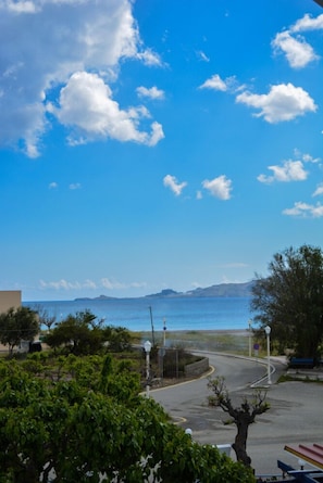 Una carretera costera con vista despejada al mar y montañas a lo lejos.