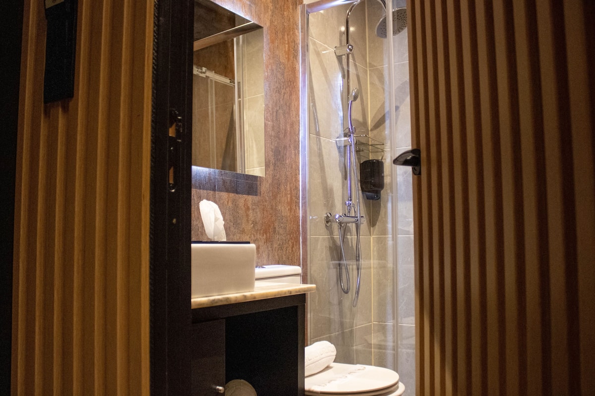 Ein modernes Badezimmer mit einer Duschkabine, einer Toilette und einem Waschbecken mit Handtuch.