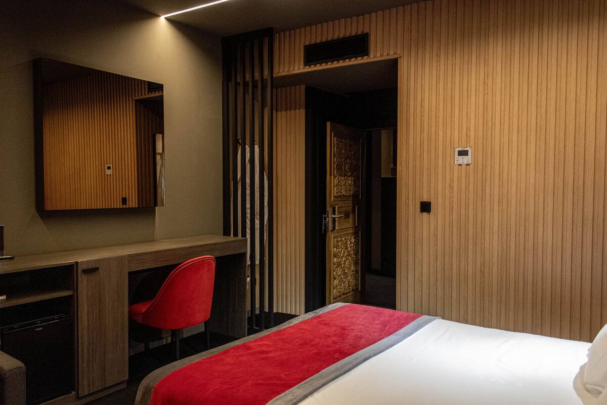 Ein Hotelzimmer mit einem Bett, einem Schreibtisch und einem roten Sessel.