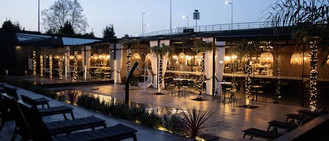 Una piscina cubierta, una piscina al aire libre, sombrillas, tumbonas