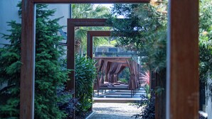 A pathway leading to a covered seating area with a view of a building in the background. - Rubens Hotels & SPA (Vila Nova de Gaia)