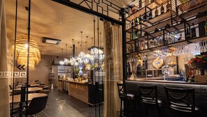 A restaurant with a bar area, seating, and a chandelier. - Rubens Hotels & SPA (Vila Nova de Gaia)