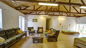 A rustic interior with wooden beams, a sofa, chairs, and a small table. - Nengshof (Wissmannsdorf)