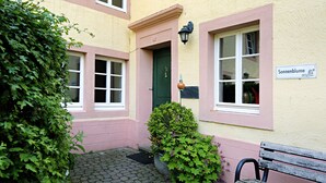 A building with a green door, a bench, and a sign that reads "Sonnenblume." - Nengshof (Wissmannsdorf)