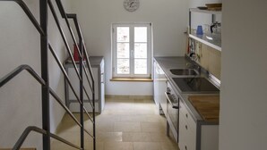 A kitchen with a window, a sink, and a staircase. - Nengshof - Haus Gänseblümchen (Wissmannsdorf)