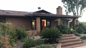A brick house with a covered porch, a satellite dish, and a chimney. - Tucson Gem in the Heart of the Desert (Tucson)