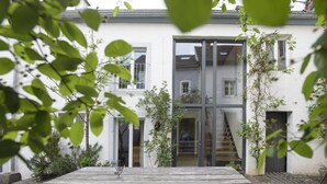 A modern building with a wooden deck and potted plants. - Nengshof - Haus Wildrose (Wissmannsdorf)