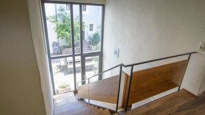 A wooden staircase with a metal handrail leading to a landing. - Nengshof - Haus Wildrose (Wissmannsdorf)