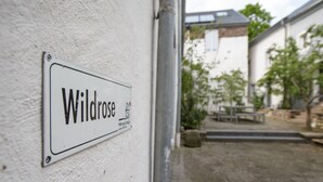 A sign on a wall that reads "Wildrose." - Nengshof - Haus Wildrose (Wissmannsdorf)