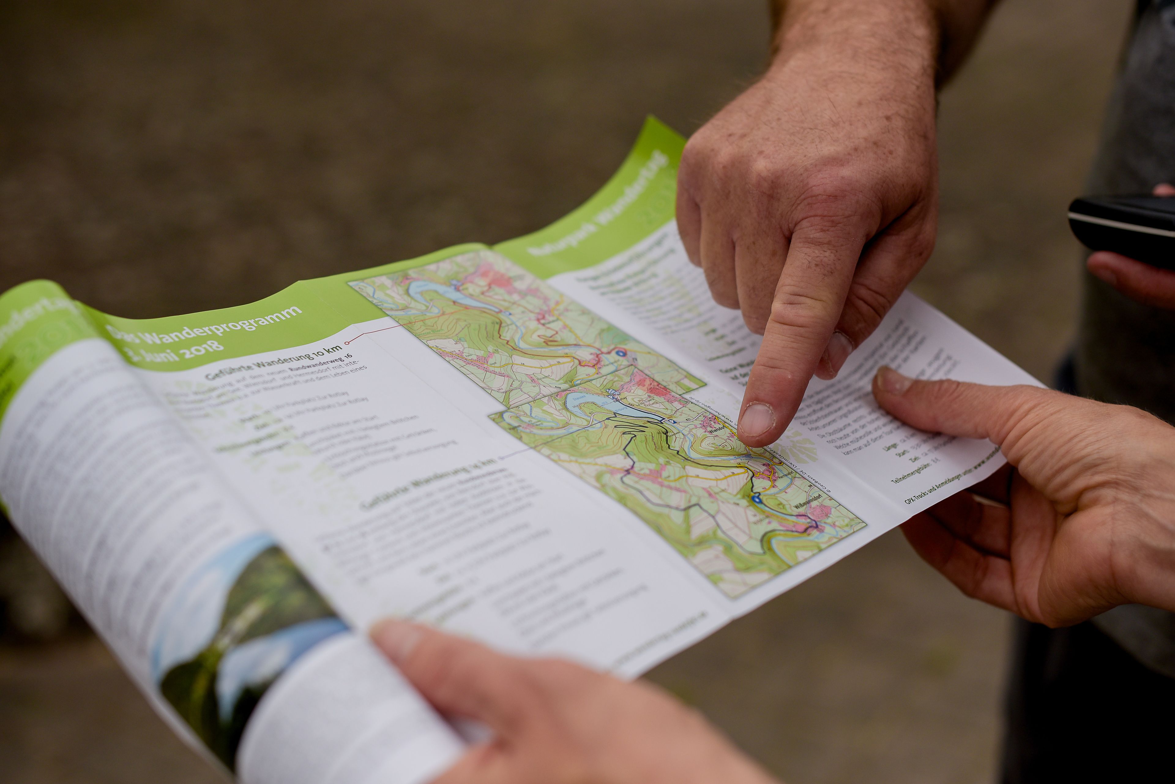 A person holding a map with text, likely a guide or itinerary.