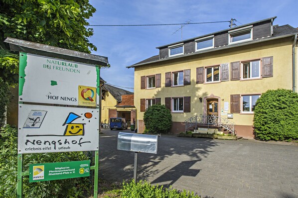 A building with a mailbox and a signboard with various symbols and text.