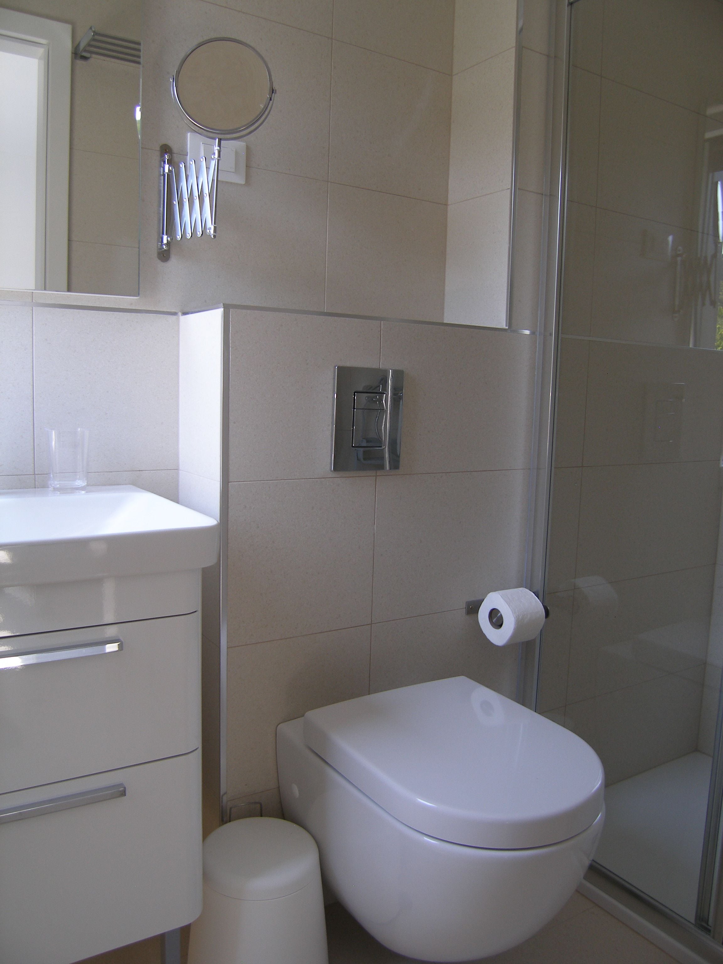 A bathroom with a toilet, sink, and shower.