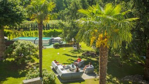 Un jardín con mobiliario exterior y una piscina.