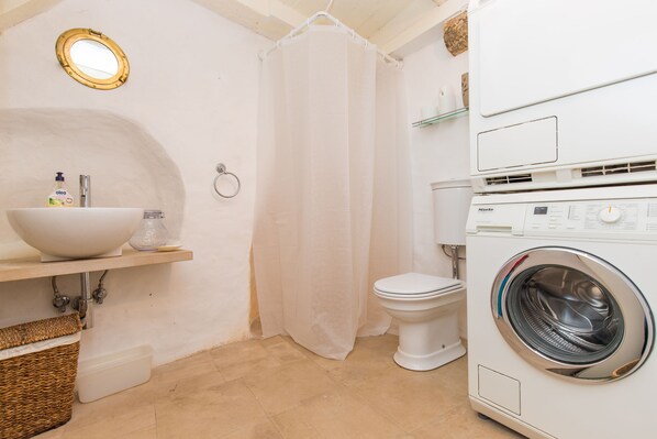 A compact bathroom with a sink, toilet, and washing machine. - House Peti (Dubrovnik)