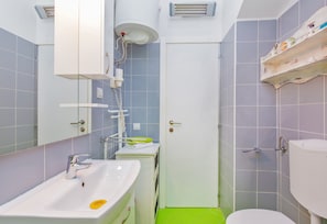 A bathroom with a sink, mirror, shower, and toilet. - Apartment & Room Joy (Dubrovnik)