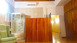 Un vestíbulo con un mostrador de recepción de madera, un área de estar con paredes de vidrio y un mueble de madera.