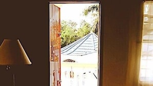 Una habitación con cama, lámpara y vistas a un edificio tradicional.