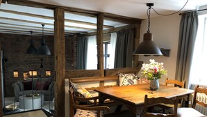 A cozy dining area with a wooden table and chairs, a bench, and a vase of flowers.