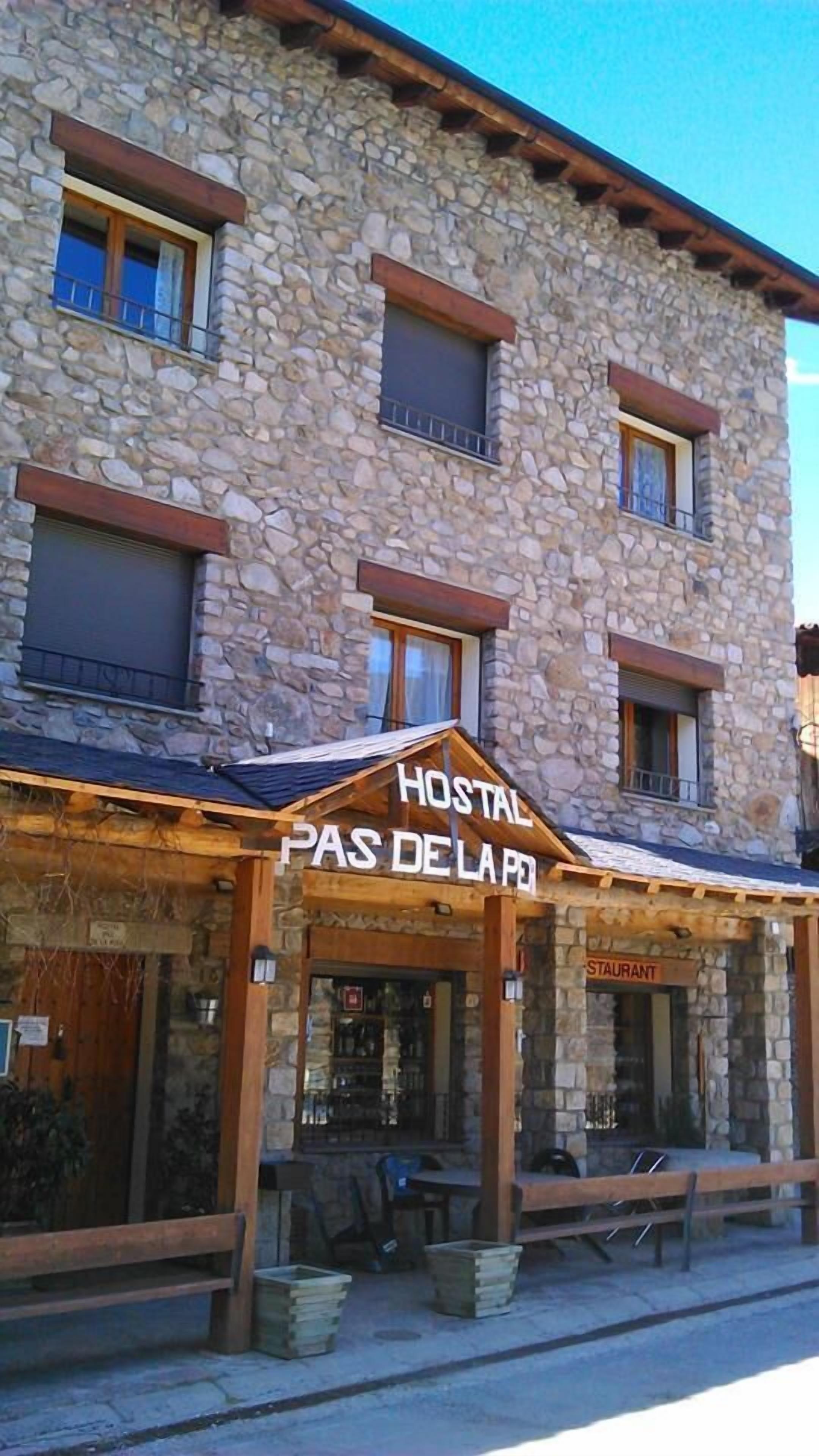 A stone building with a sign reading "HOSTAL PAS DE LA PO."