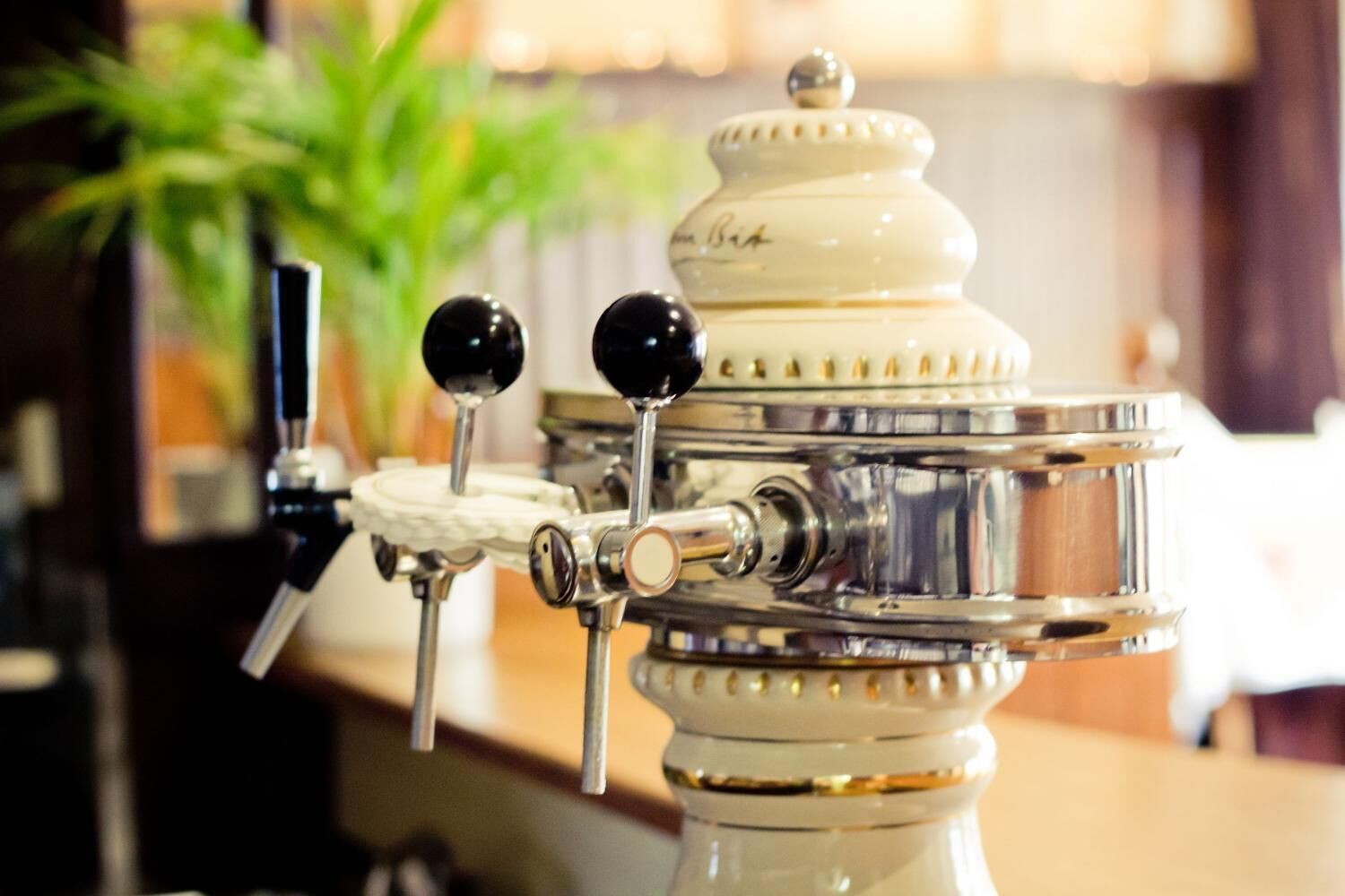 Una cafetera expreso antigua con diseño blanco y plateado, que presenta dos perillas negras y un recipiente de vidrio en la parte superior.
